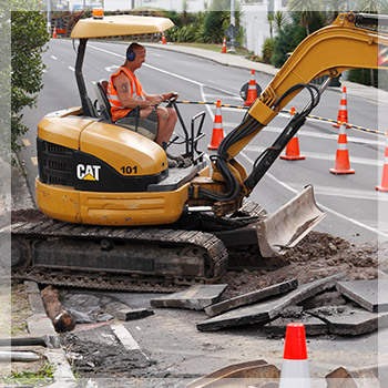 A person operating a digger on a road