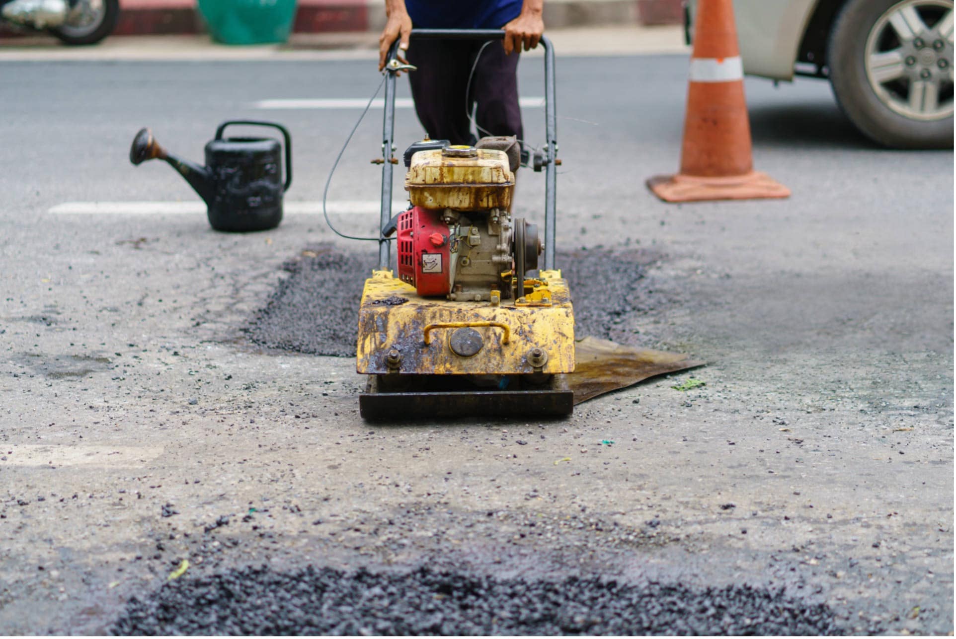 Man using machine to repair asphalt
