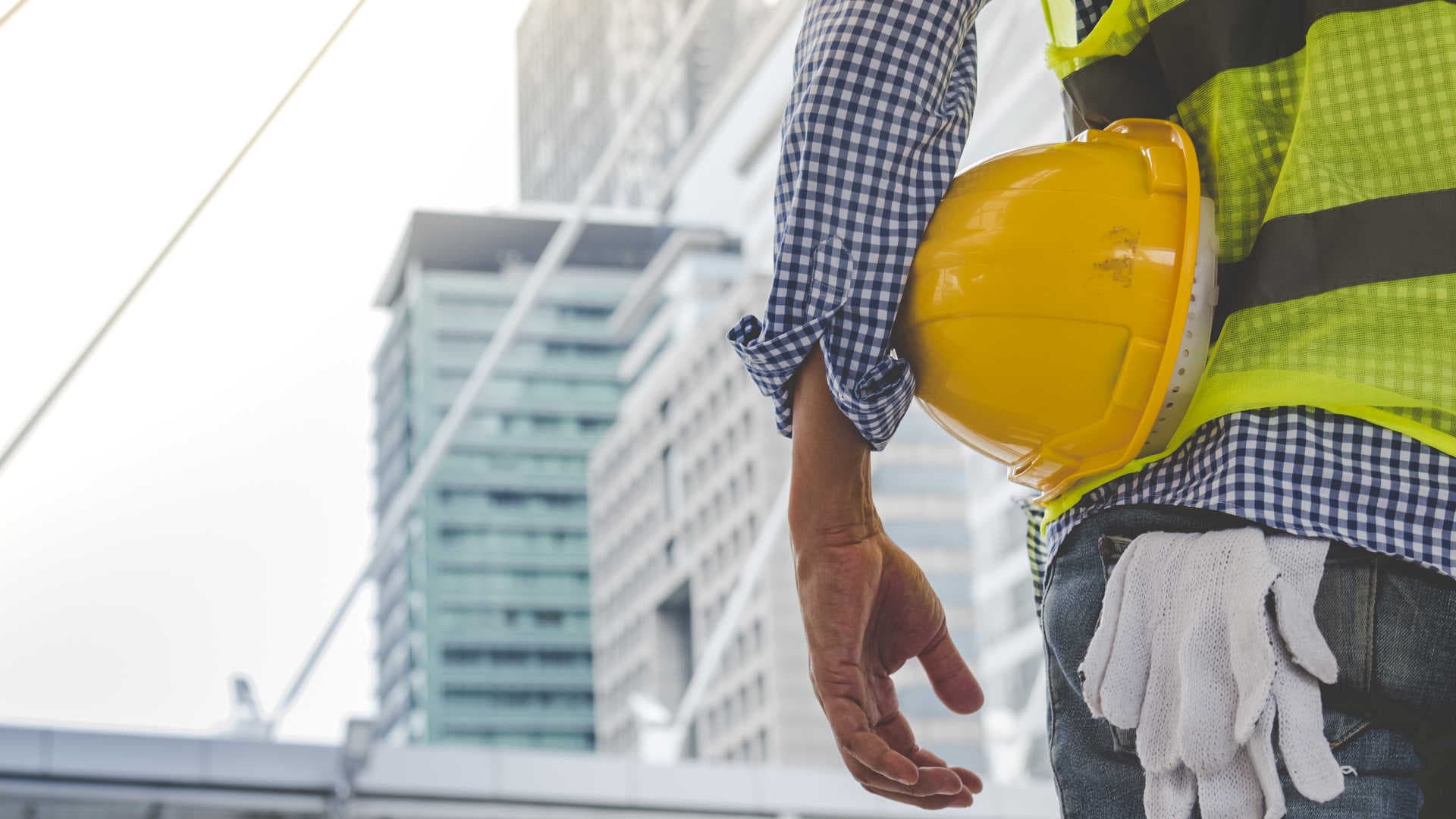 Best Civil Construction Company – Worker Overlooking Project With Helmet In Hand